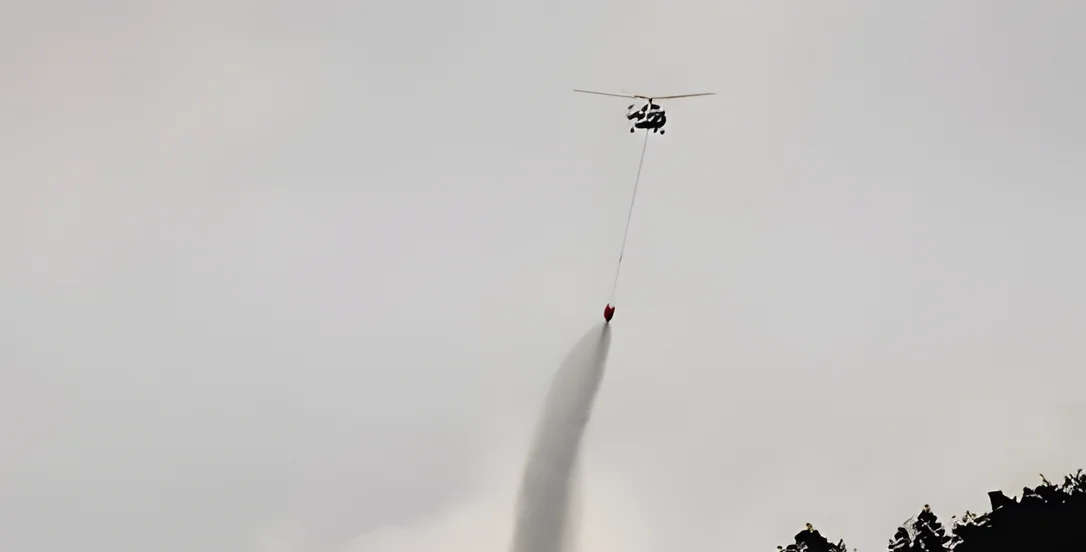 Helicopter water bombing a fire