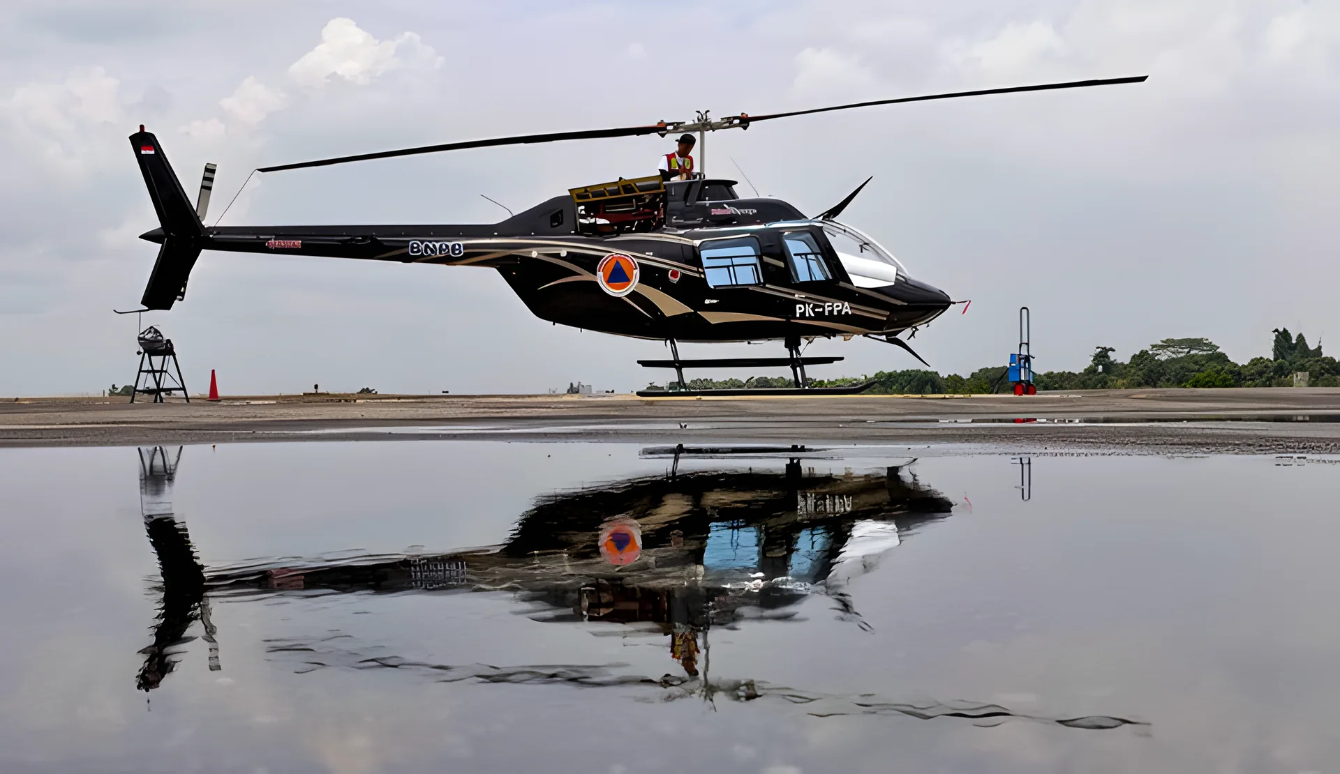 Bell 206B3 JetRanger III reflected on the wet apron