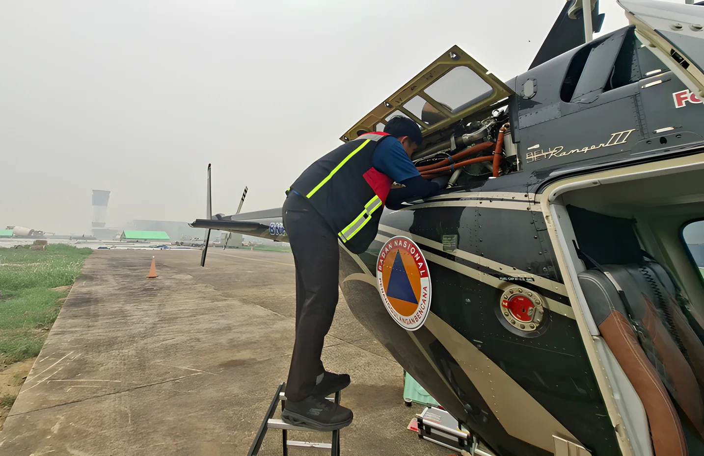 Crew member checking the Bell 206B3 before a fire patrol